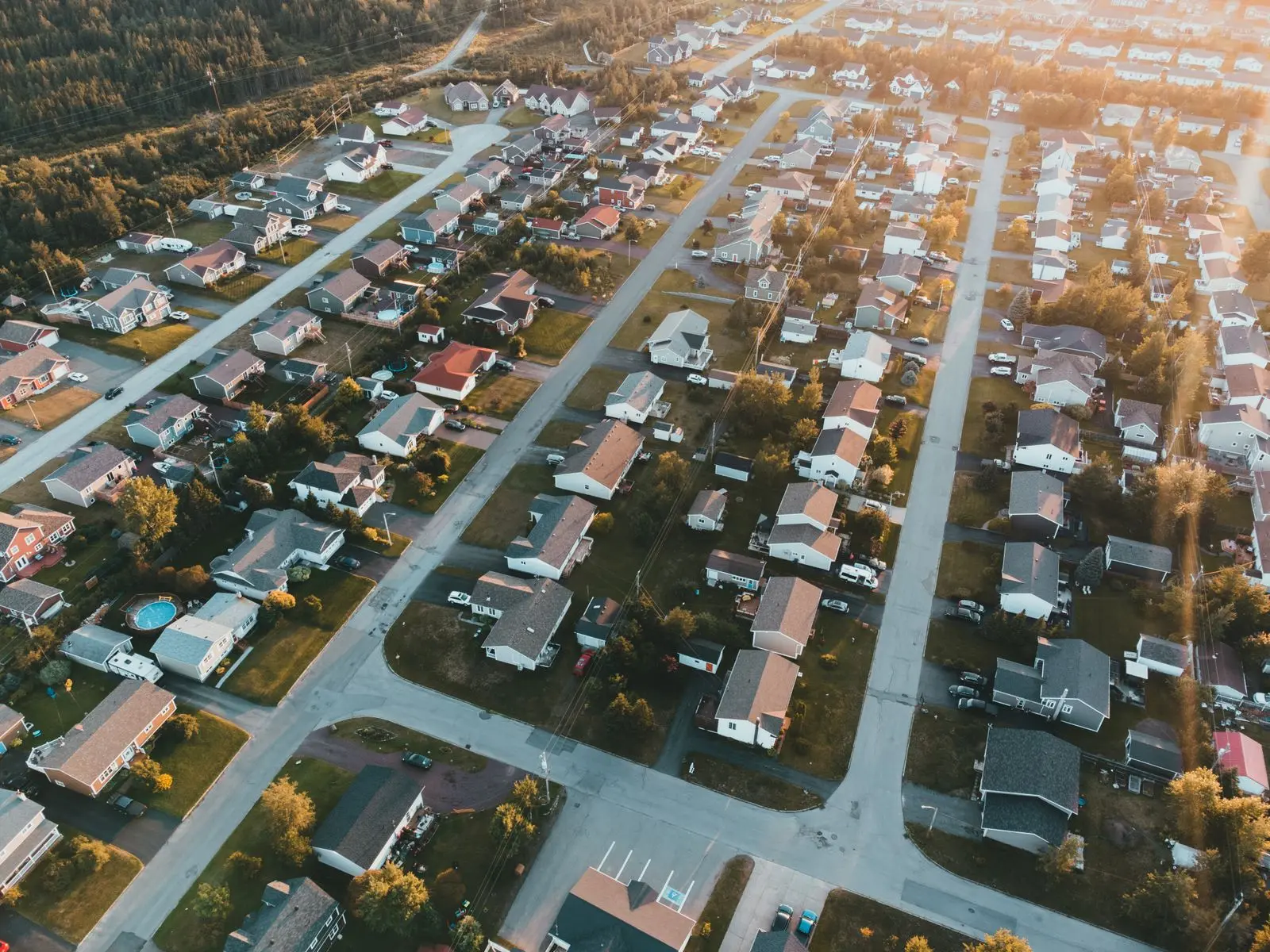 A suburban grid of houses from the air at golden hour