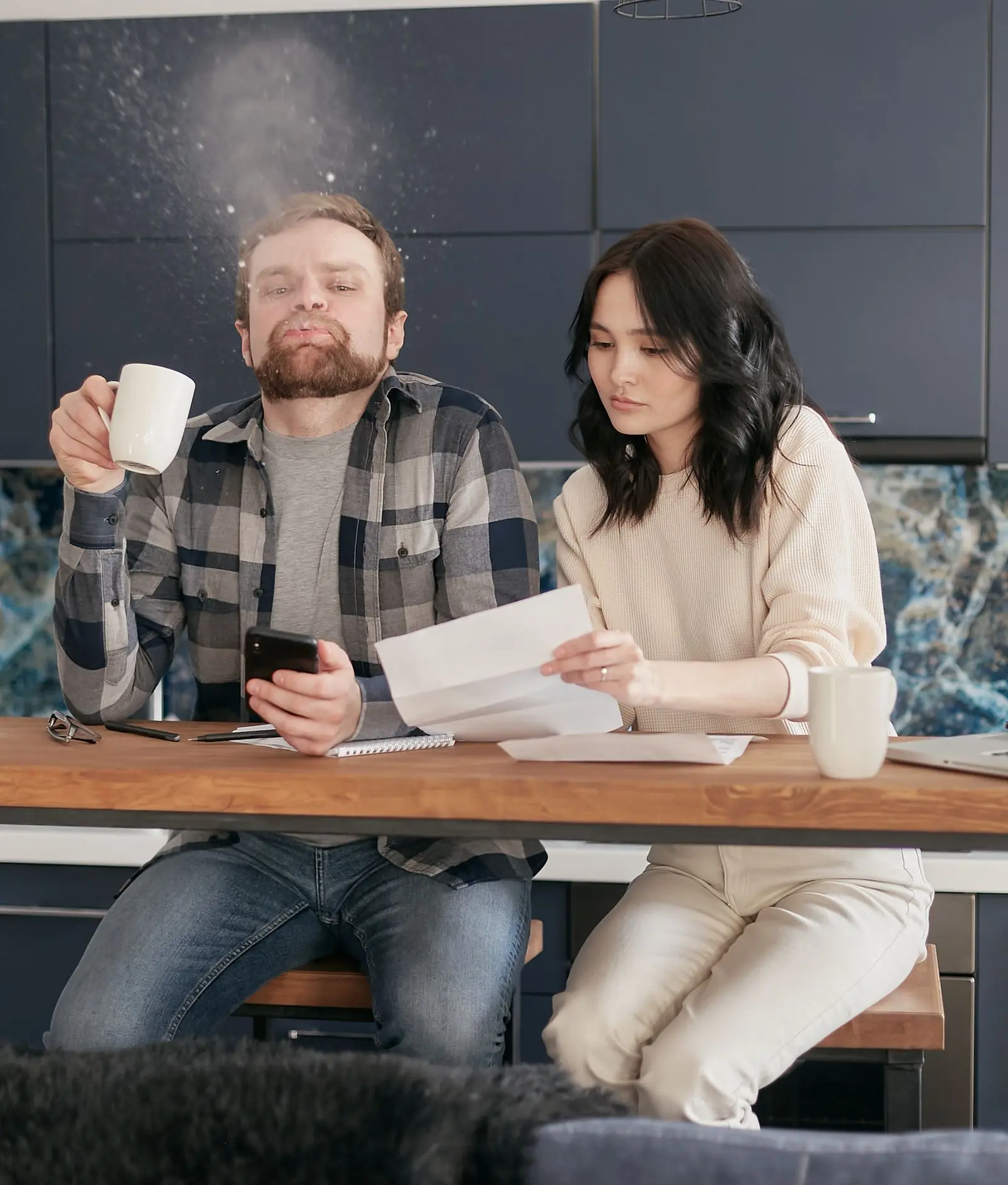 A couple going through household bills at the kitchen table