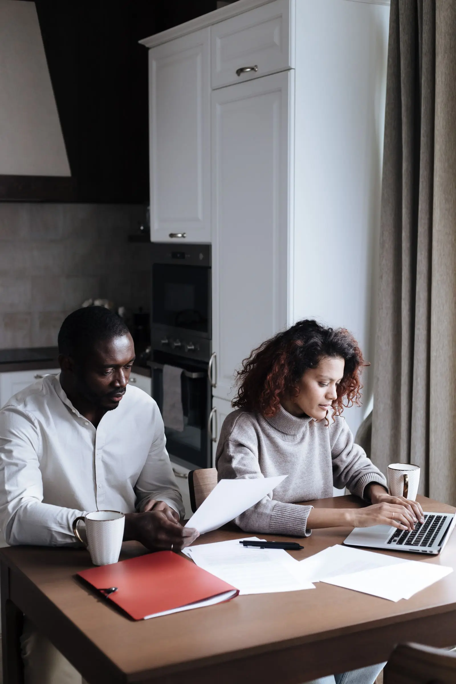 A couple reading paperwork together at home