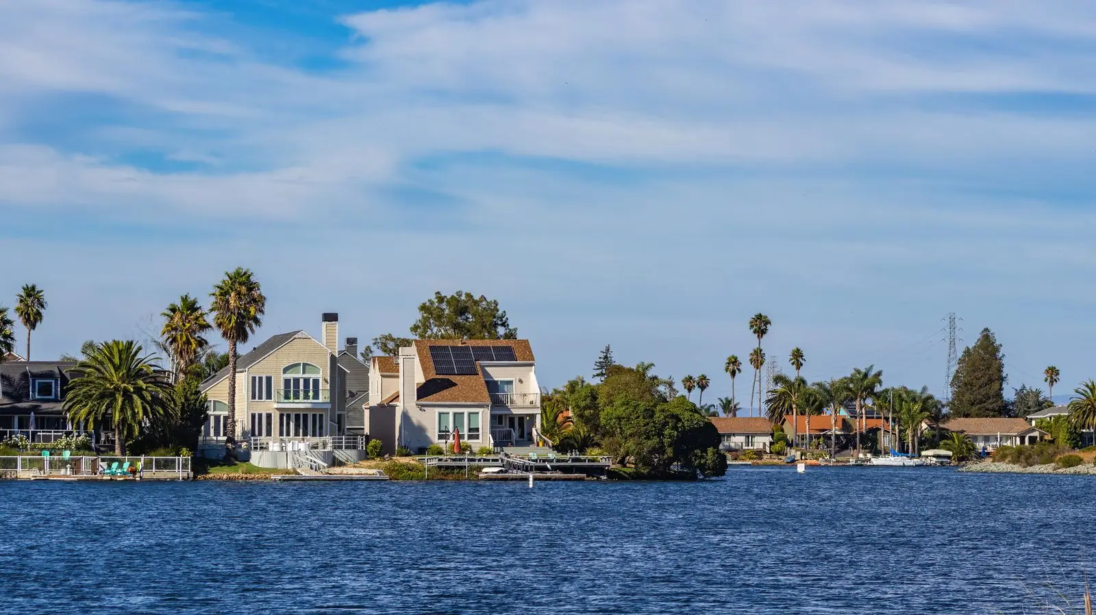 Waterfront homes with palm trees under a blue Florida sky
