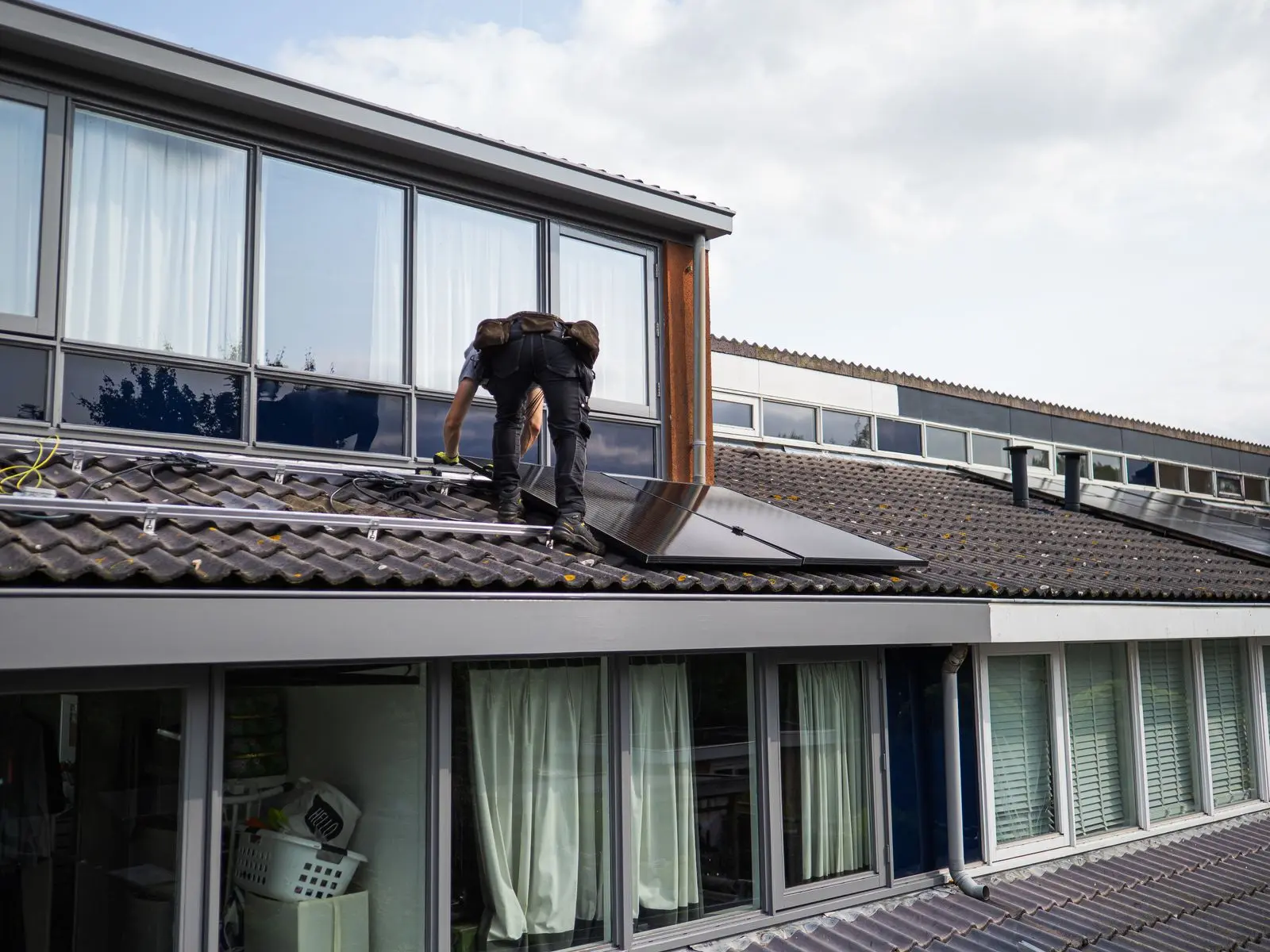 A technician working on a roof-mounted solar array