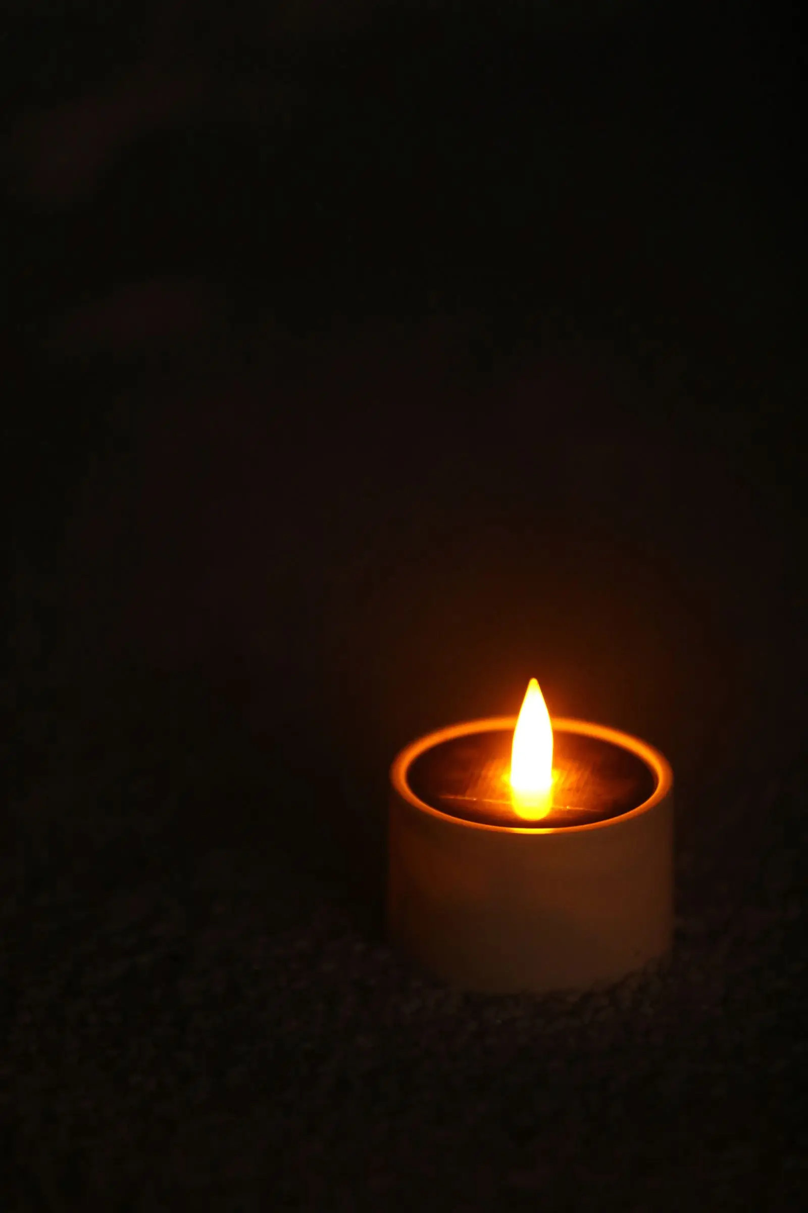 A single candle burning in a dark room during a power cut