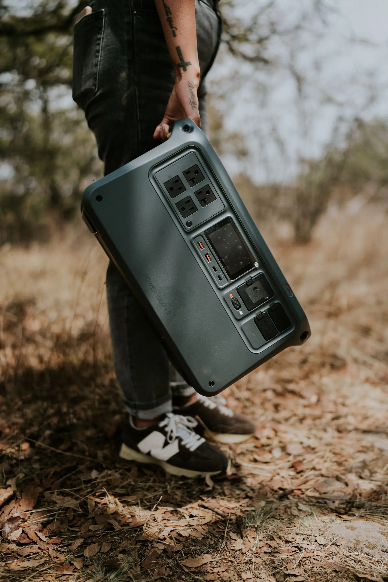 A hand carrying a portable power station outdoors
