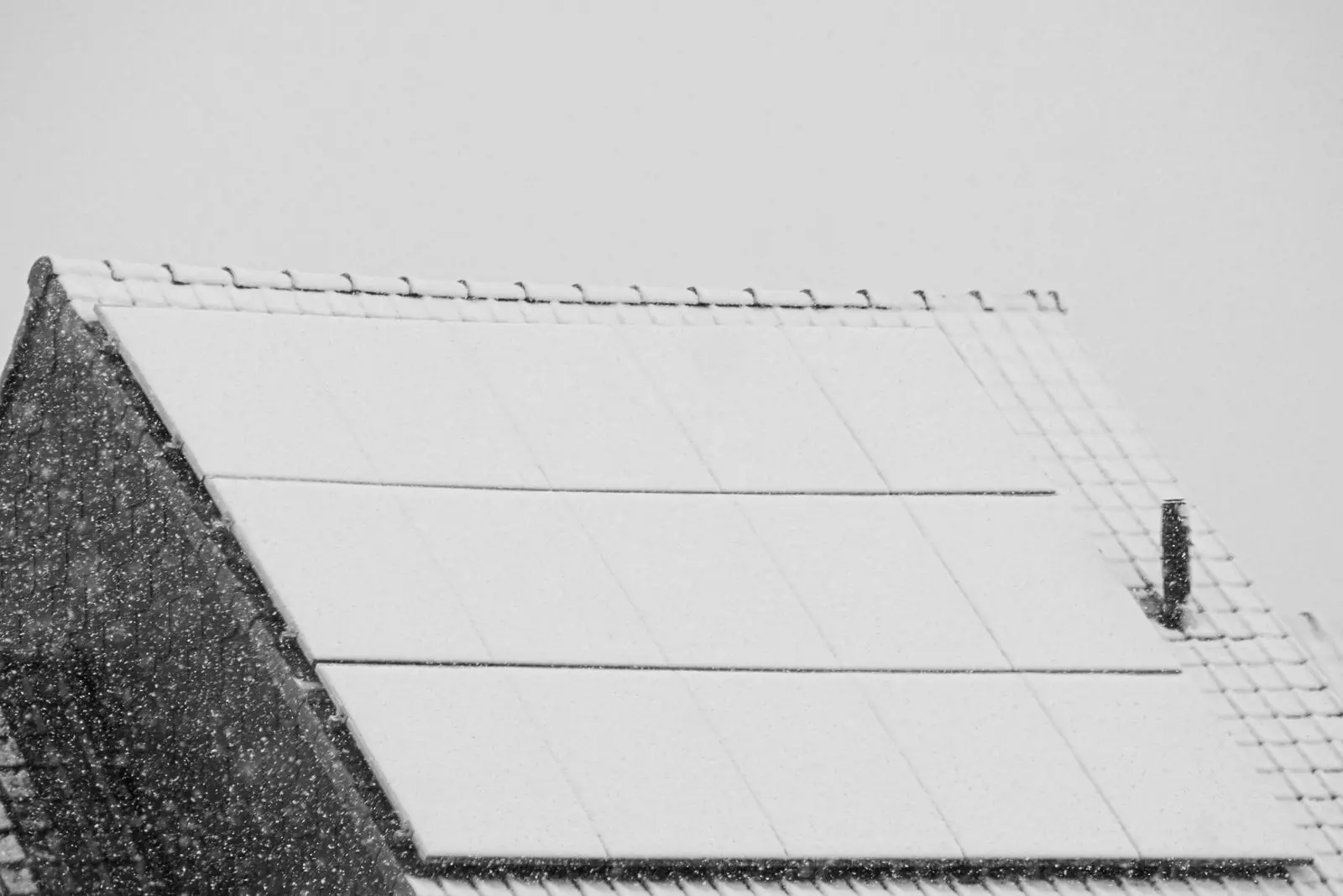 Solar panels on a roof covered by fresh snow