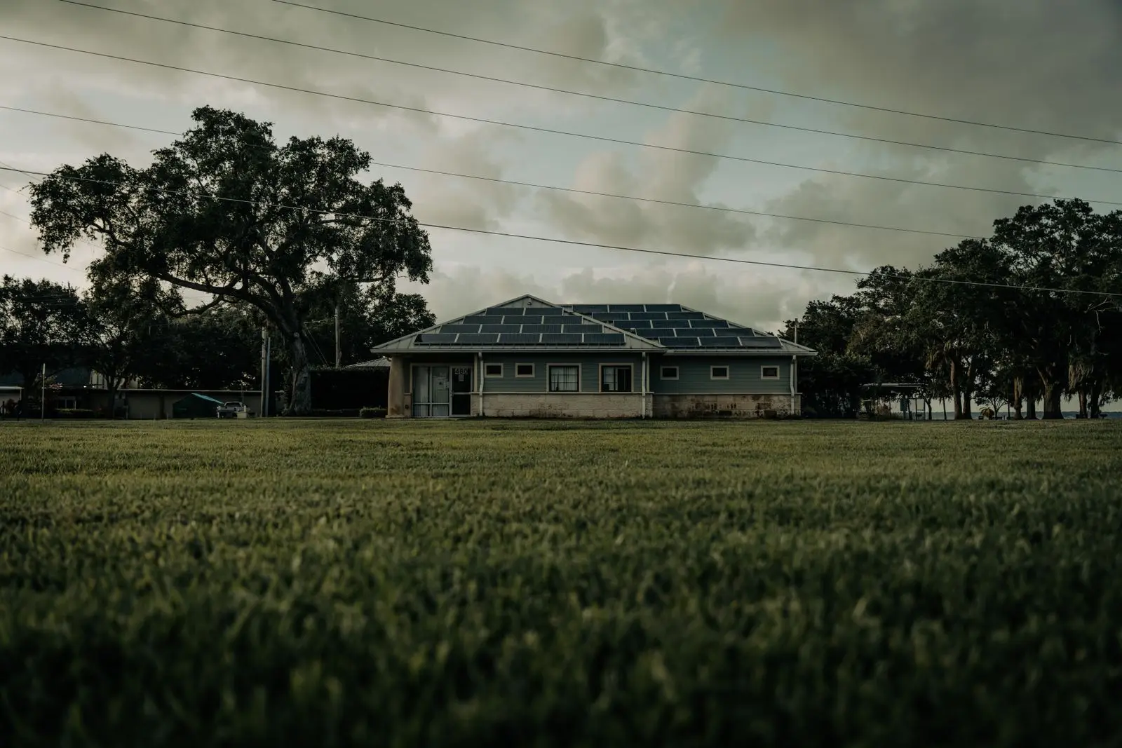 A single-storey house under dark storm clouds